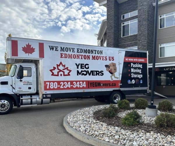 Moving truck parked outside apartment building.